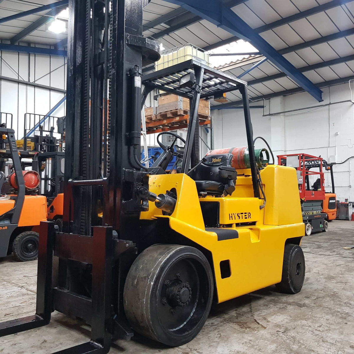 Fork trucks lifting pallets in warehouse environment