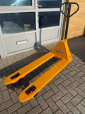 Manual pallet jack with 2000kg capacity, ergonomic pump handle, sturdy steel frame, and smooth wheels for warehouse use